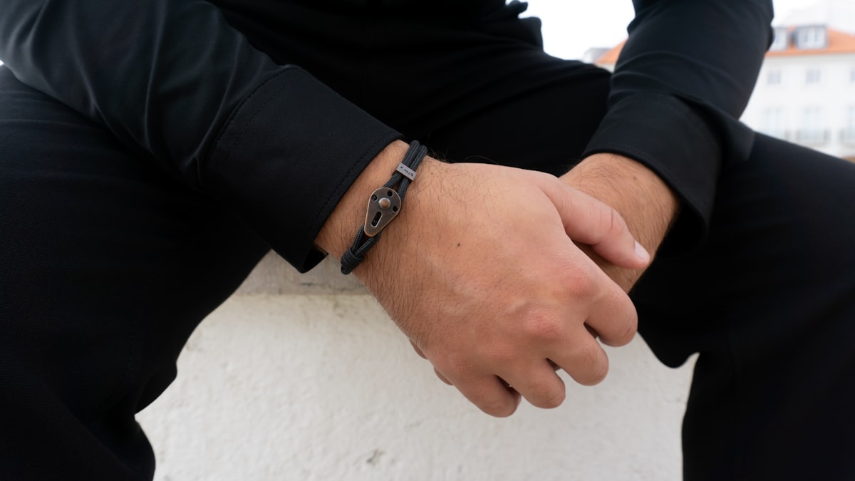 Poignet d'homme portant plusieurs bracelets en cuir et métal superposés