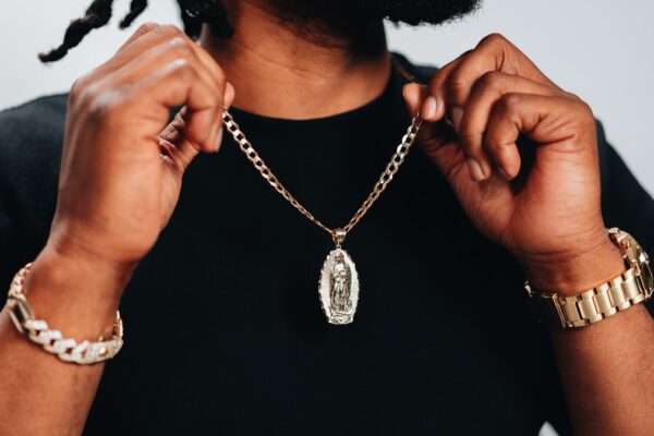 Chaîne et collier pour homme portés avec une chemise ouverte, style élégant et sobre