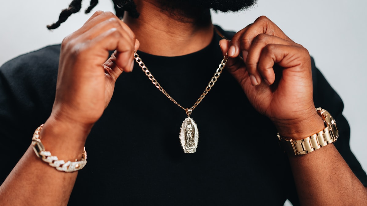 Chaîne et collier pour homme portés avec une chemise ouverte, style élégant et sobre