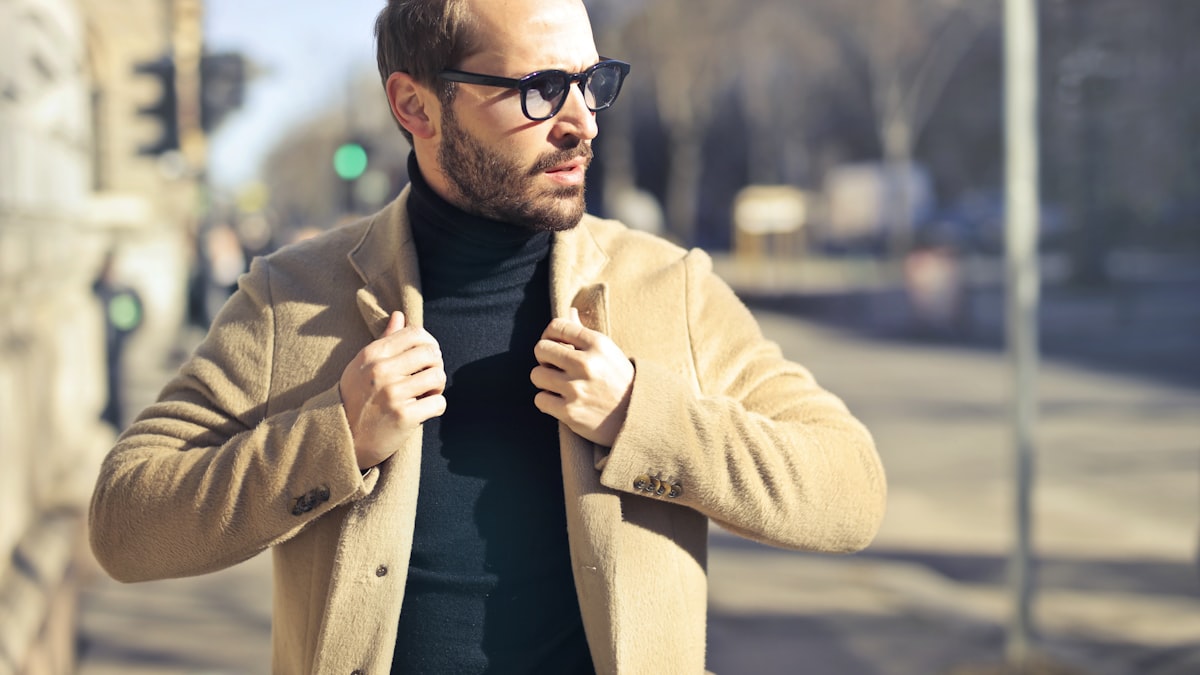 Homme en tenue old money beige et camel illustrant le style quiet luxury masculin