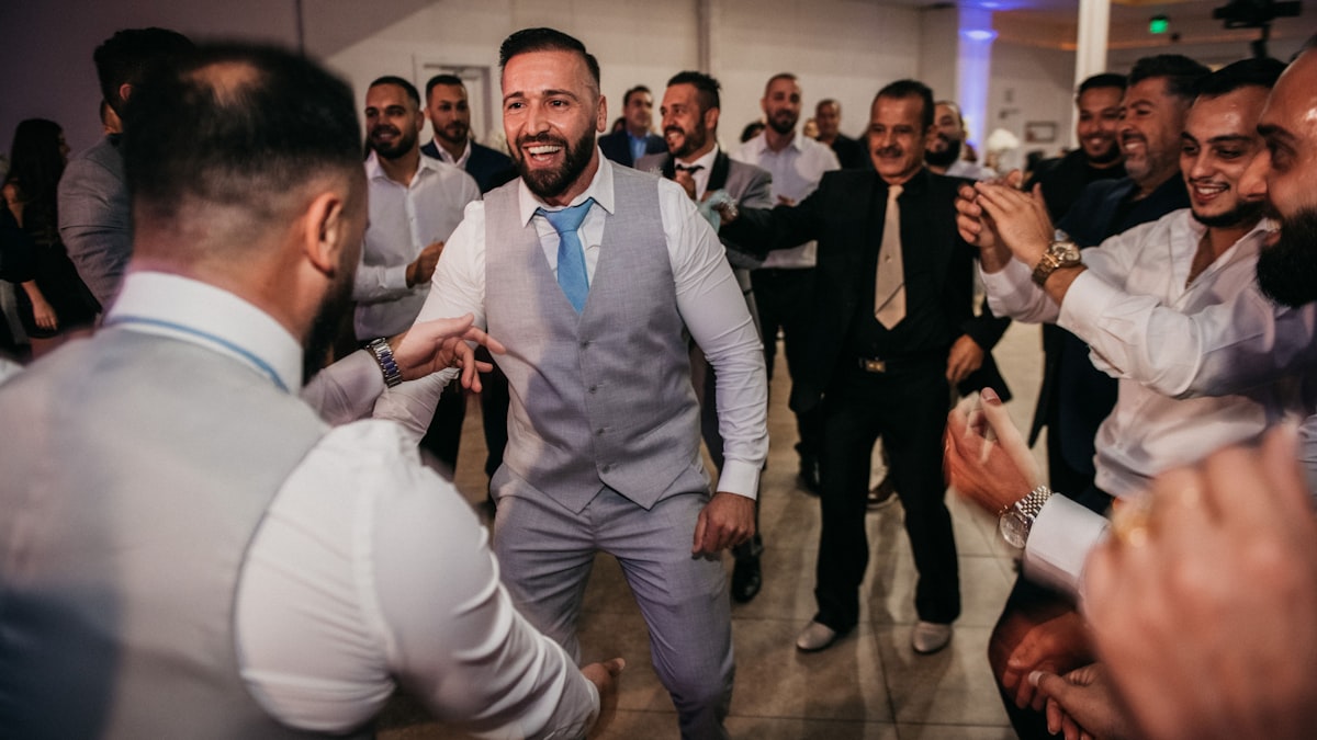 Homme invité à un mariage en costume bleu marine avec cravate et pochette de costume